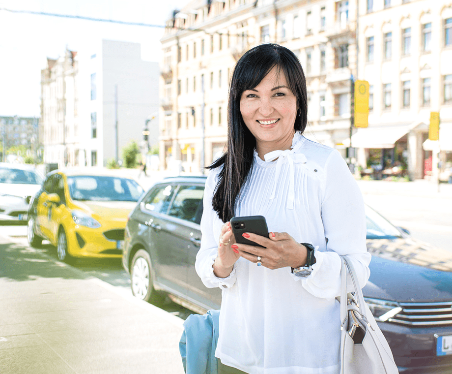 Eine Frau am Mobipunkt hat ein Mobiltelefon in der Hand